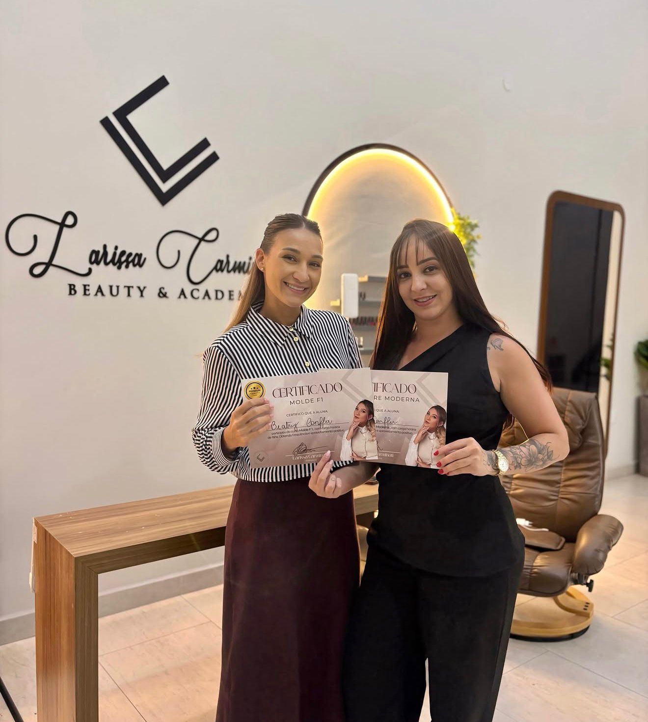 Aluna formada exibindo certificado no estúdio Larissa Carminati